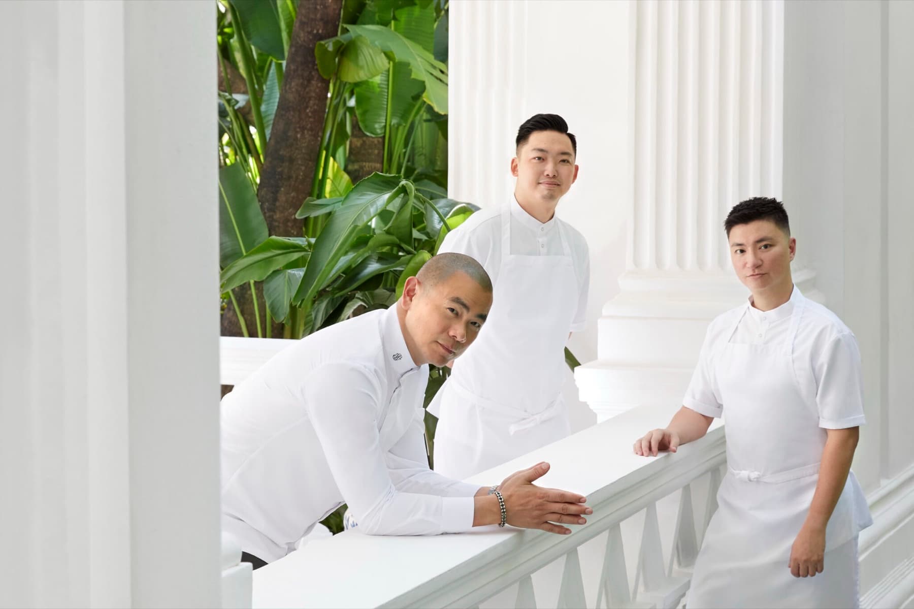 André Chiang with chefs Ben Wang and Roy Kuo in white coats on a Raffles Hotel balcony