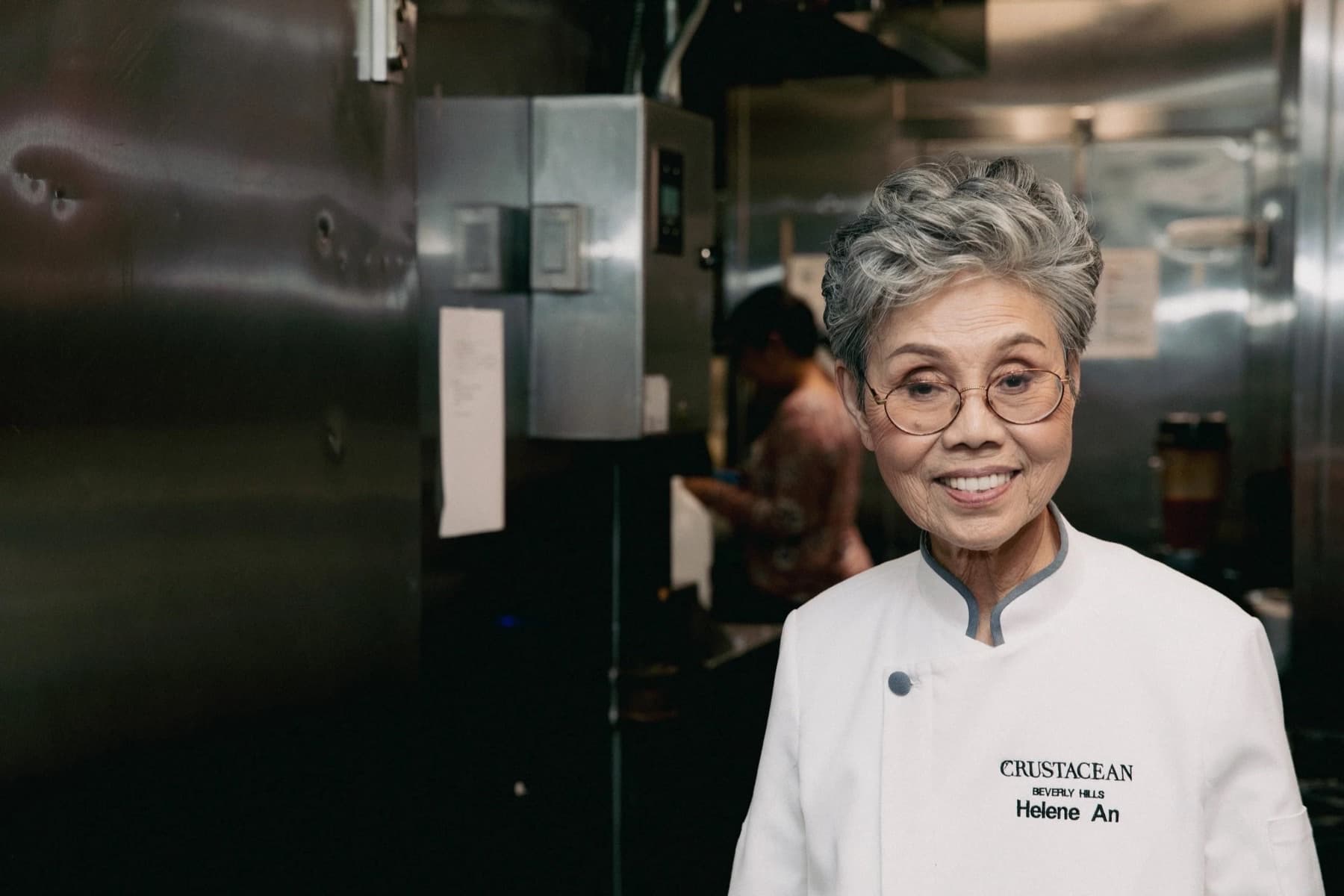 Chef Helene An in a white chef’s coat smiling in the Crustacean kitchen