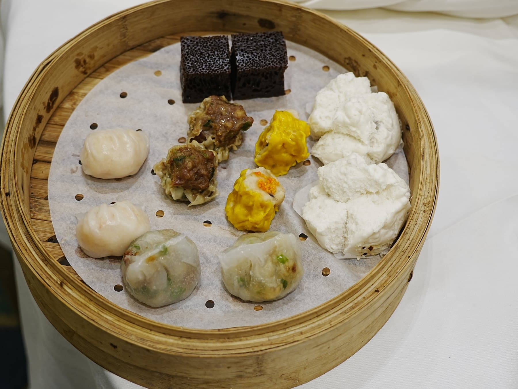 Bamboo steamer with har gow, siu mai, char siu bao, and other classic dim sum