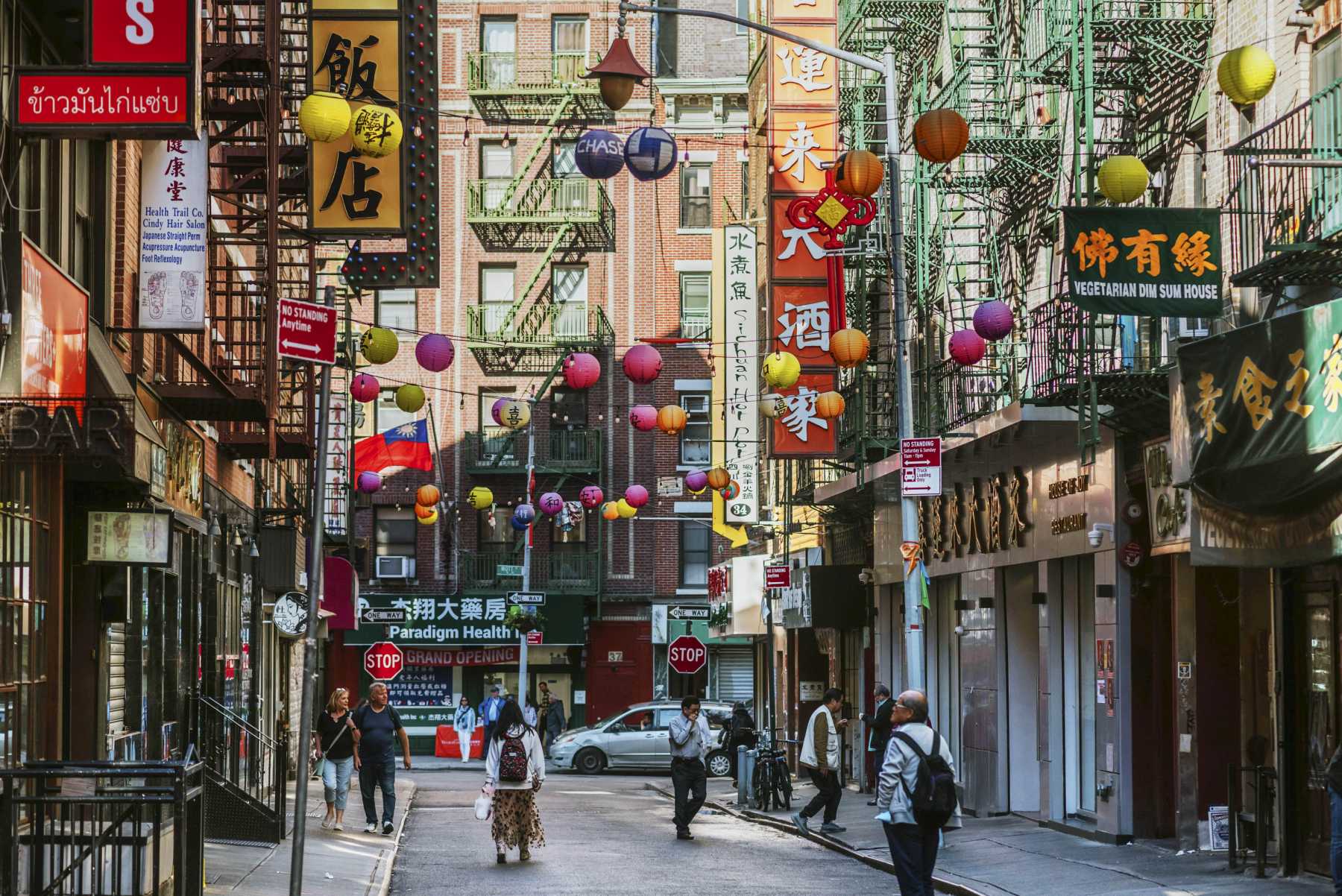 Pell Street at Mott Street in Manhattan Chinatown, lanterns over restaurant signs