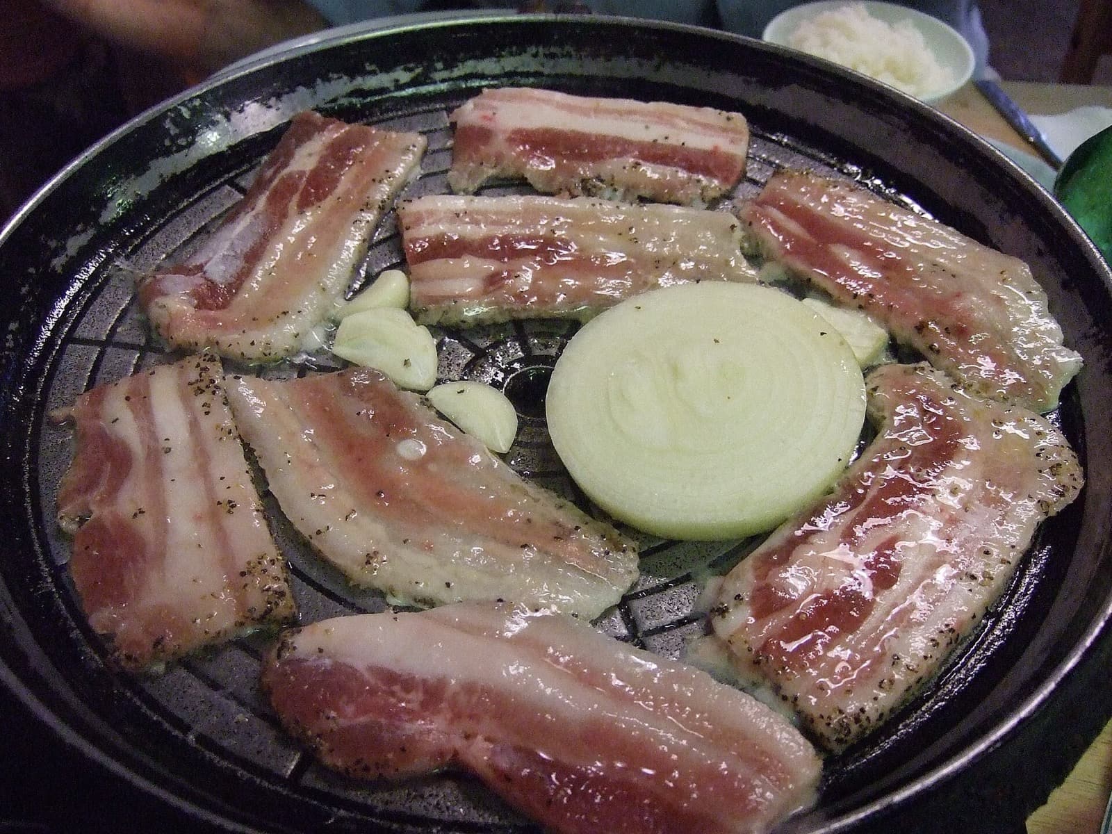 Grilled samgyeopsal pork belly on a Korean barbecue grill plate