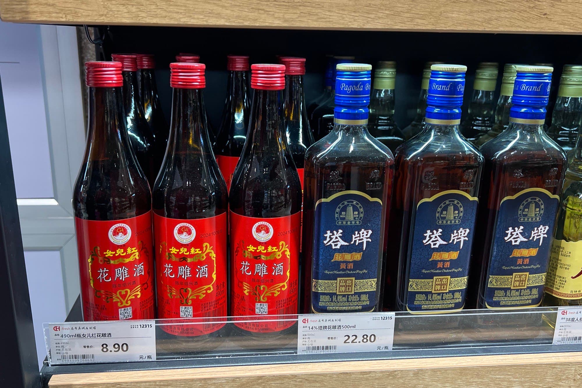 Supermarket shelf of bottled Shaoxing huadiao wine with red and blue labels