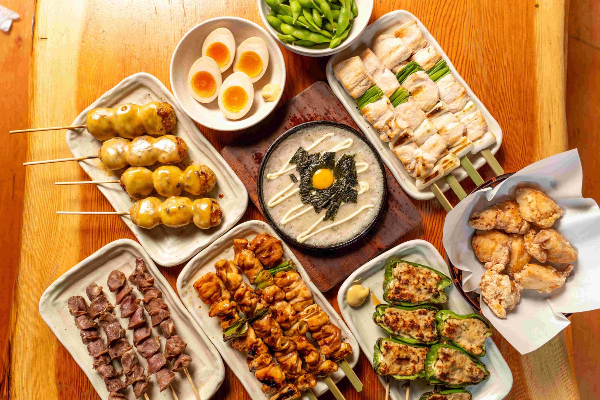 Table spread of Torikizoku yakitori skewers, cheese tsukune, karaage, and sides
