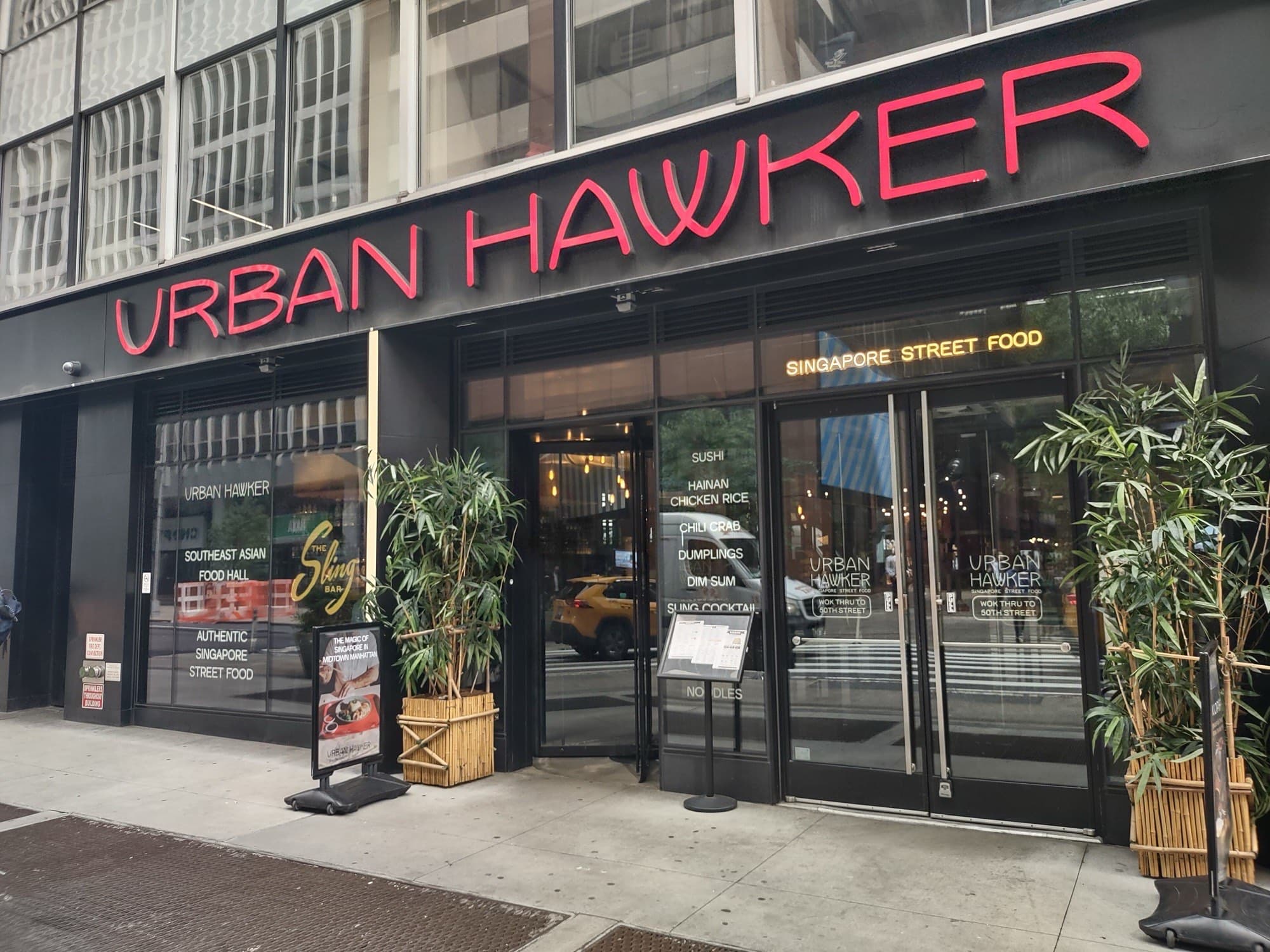 Urban Hawker storefront on West 50th Street with red lettering and Singapore street food neon